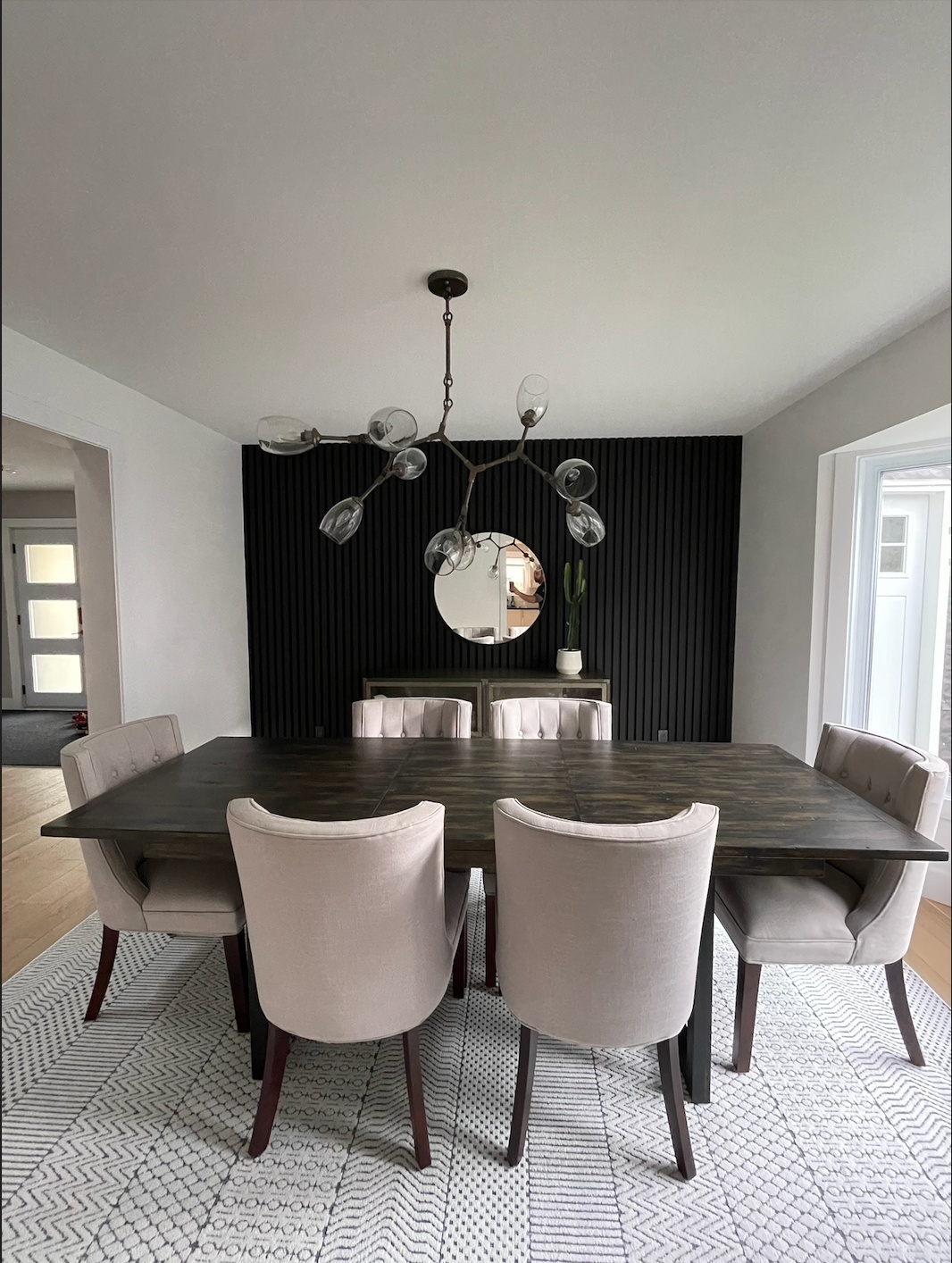 Finished dining room with black accent wall and pendant lighting