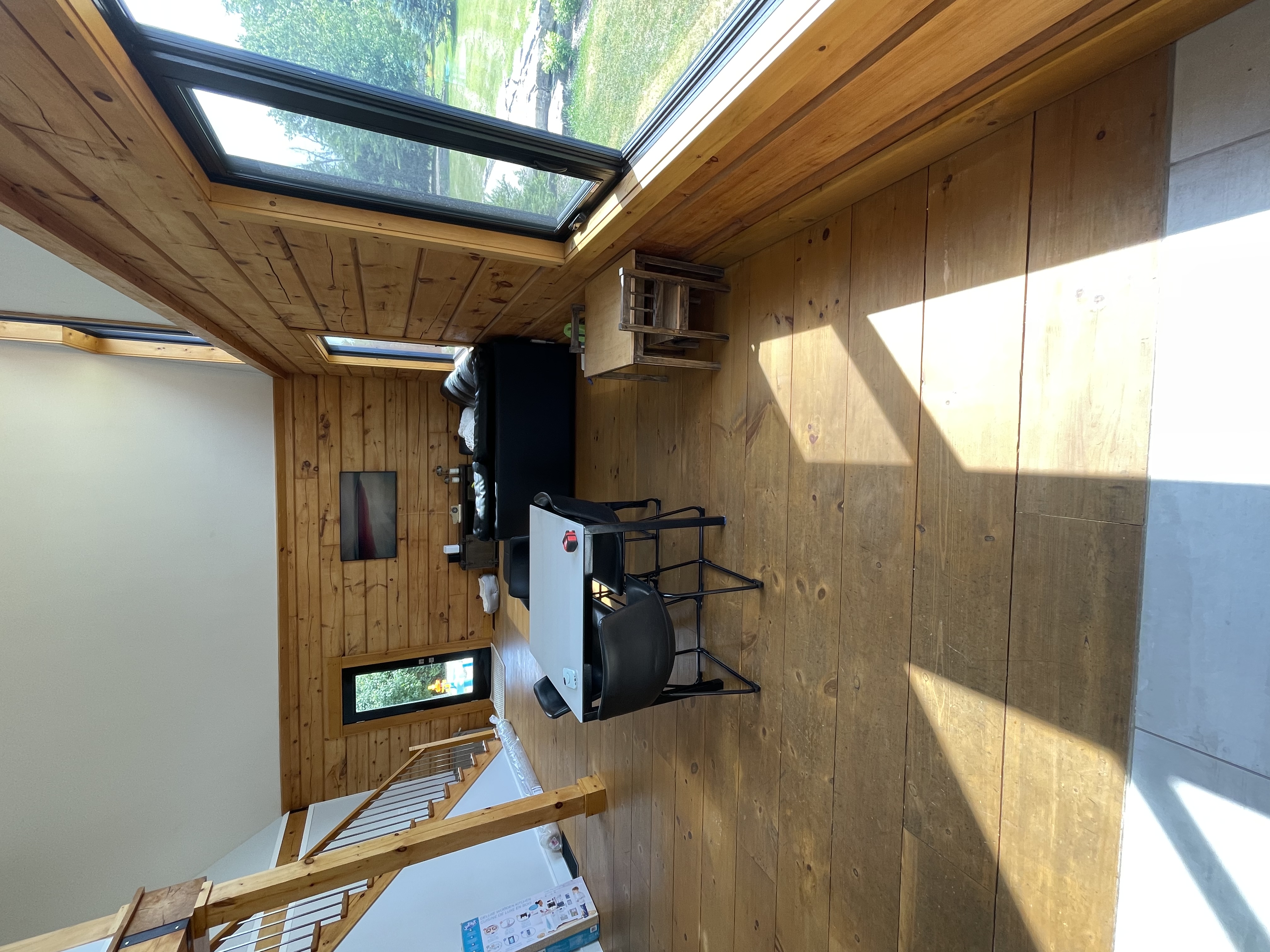 Bright, wood-paneled great room with vaulted ceiling and large windows