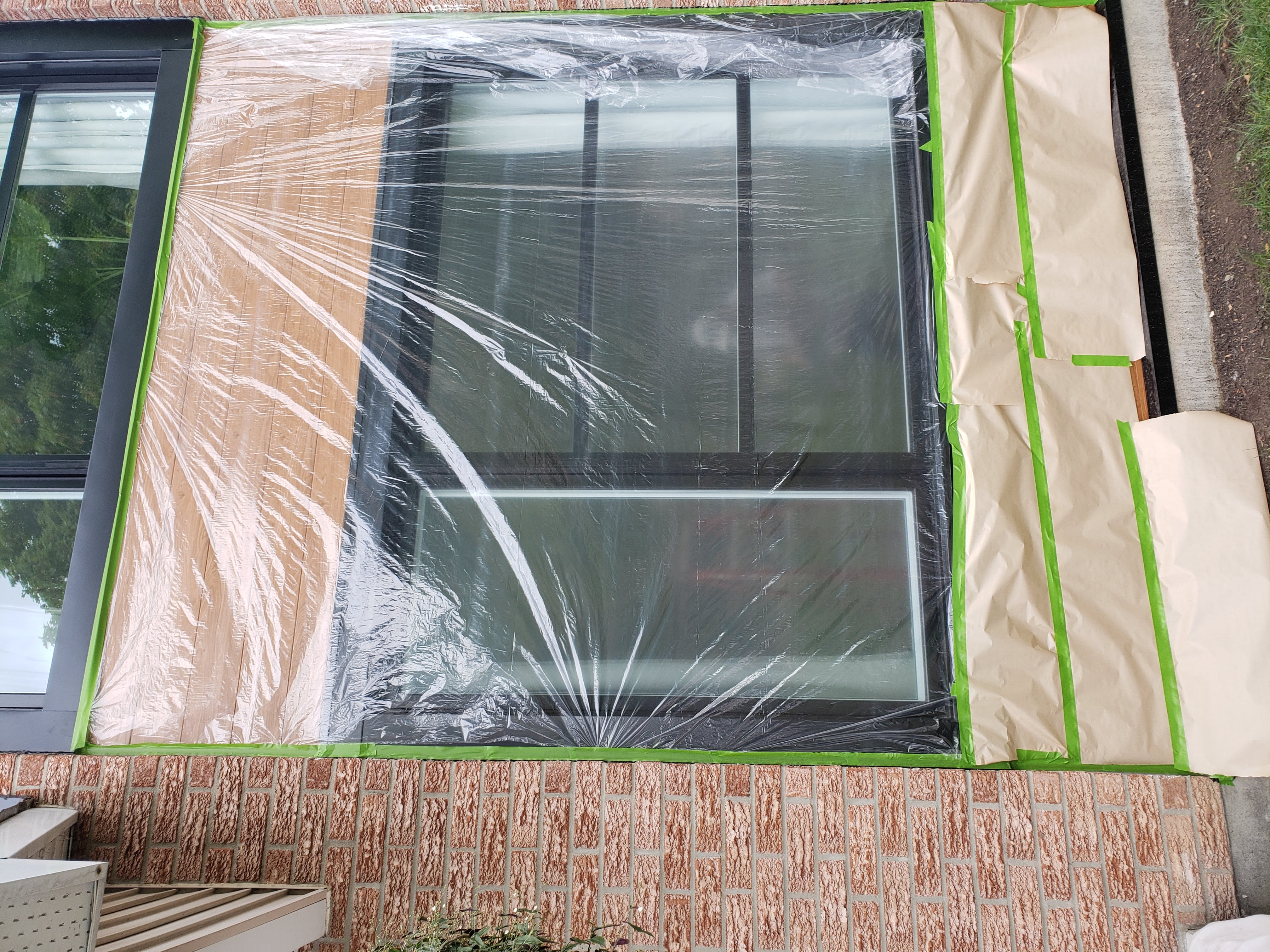 Window fully masked with plastic sheeting and taped edges